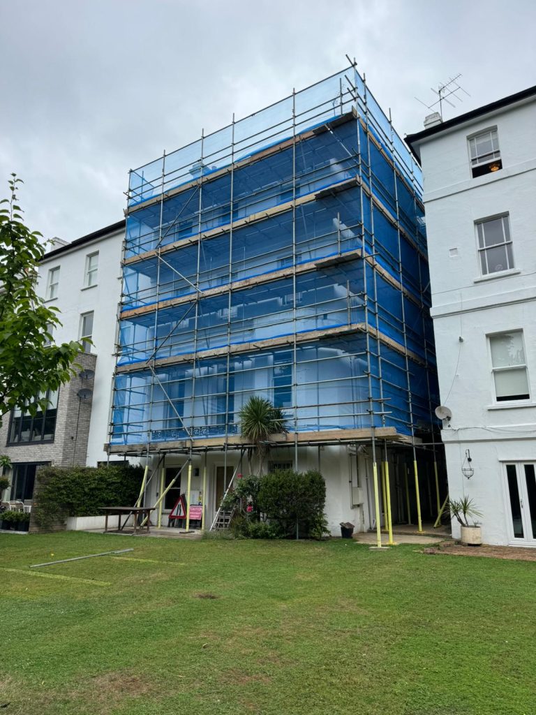 Scaffolding services in London on a residential building with blue safety netting for exterior renovation
